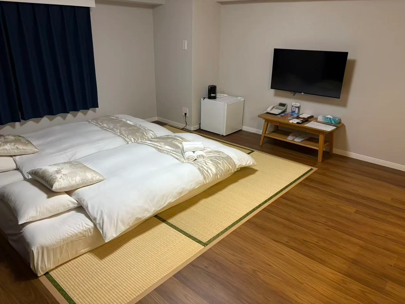 木目の床と畳スペースに布団を並べた客室