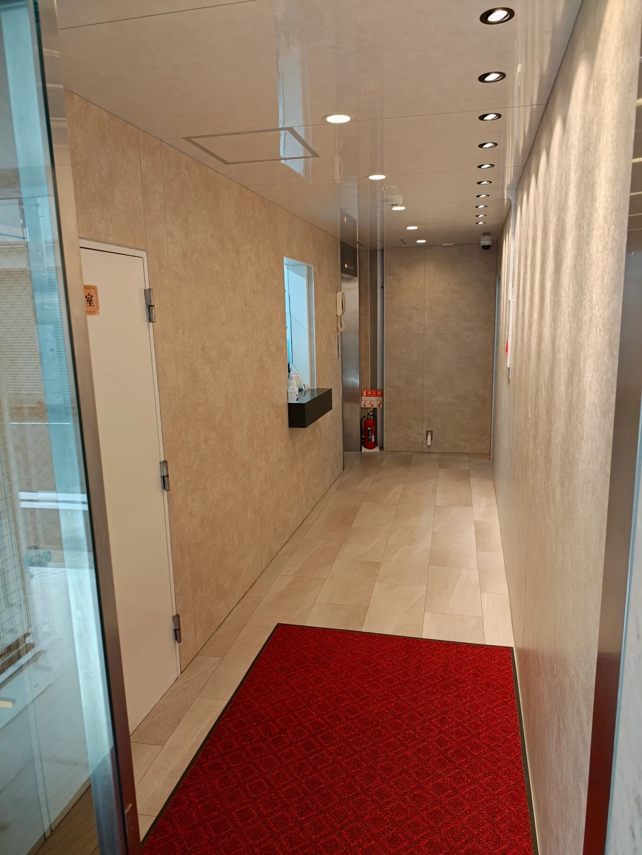 明るいタイルと赤いマットがあるHOTEL BUSTELの入口
